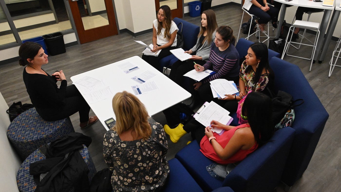 Students sitting around table with faculty member