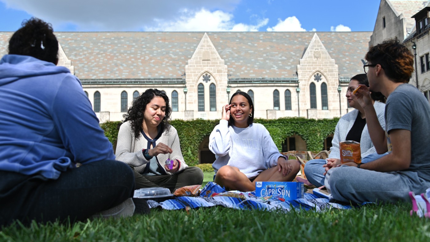 Student group snacking on campus lawn