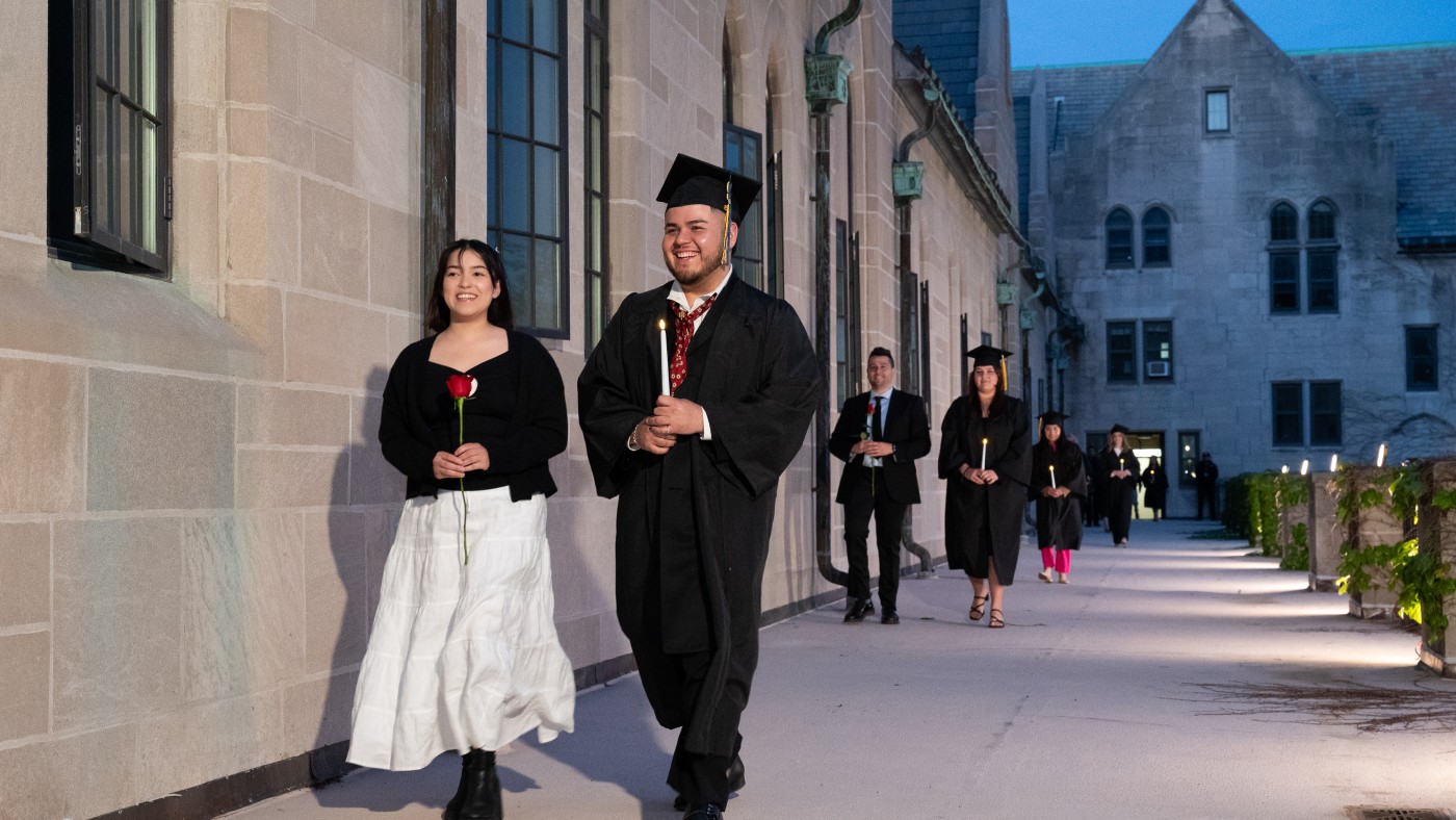 Graduating students walk across the upper Cloister Walk during the Candle and Rose Ceremony, a beloved Domininican University tradition. Graduating seniors carry candles, symbolizing veritas, and their selected parnter carries a rose, symbolizing caritas