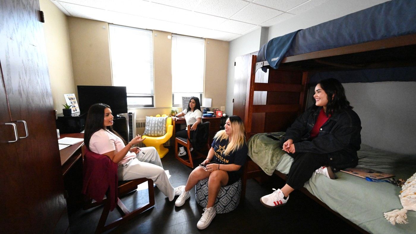 Dominican students sitting in a dorm room in Coughlin Hall.