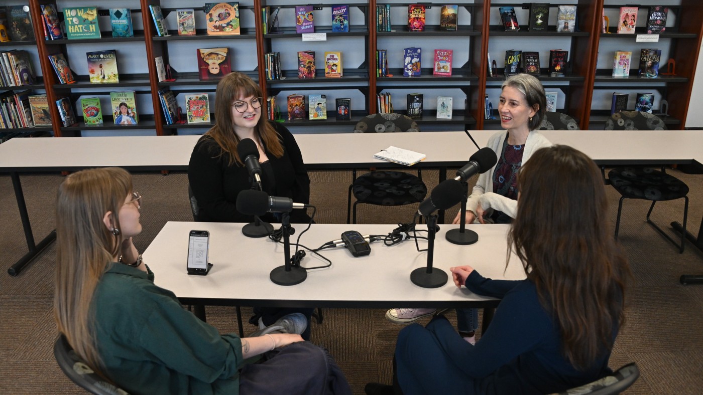 Four people gathered at a table with microphones
