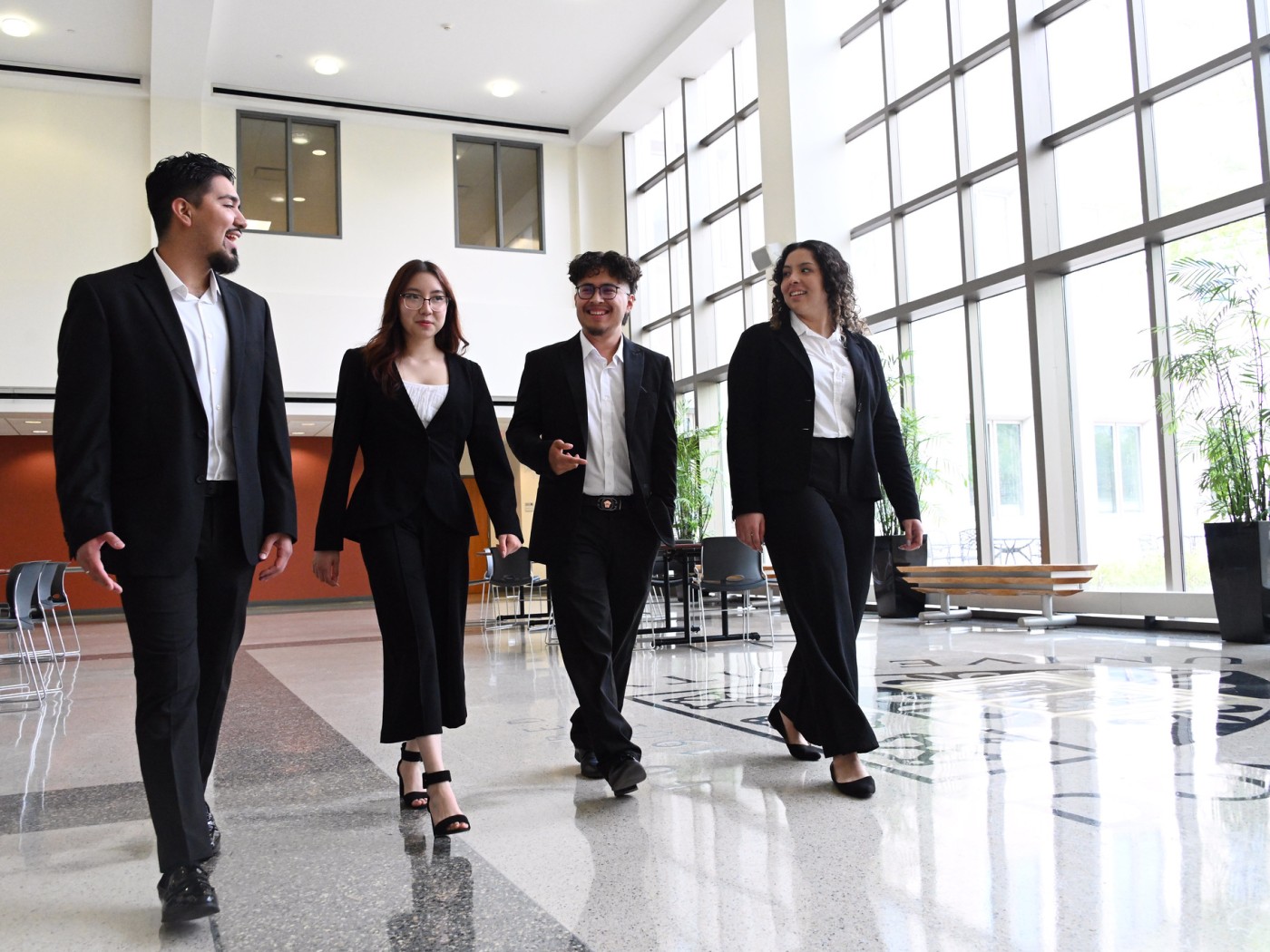 Four professionally dressed students walking