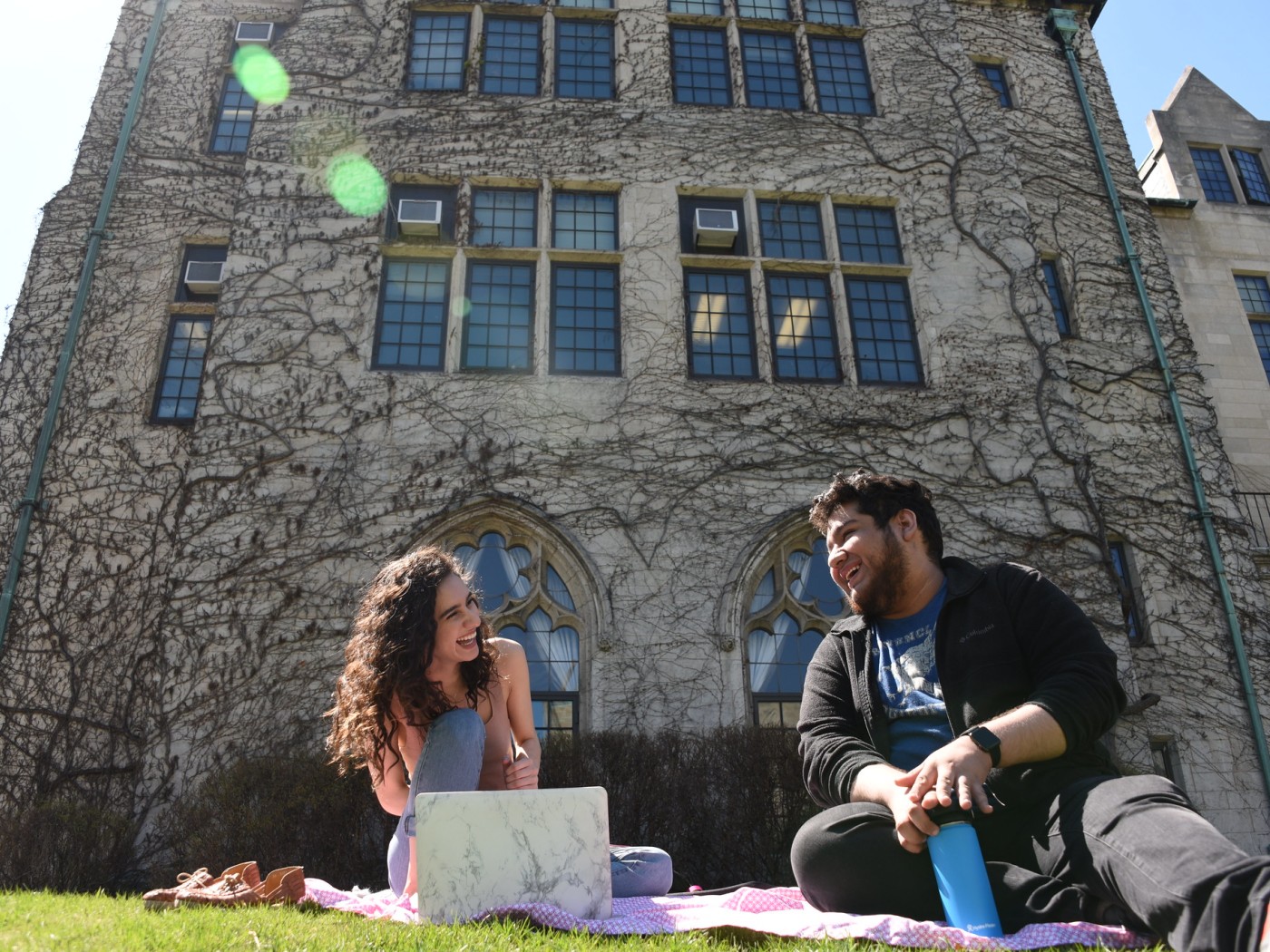 Two students on lawn outside campus building
