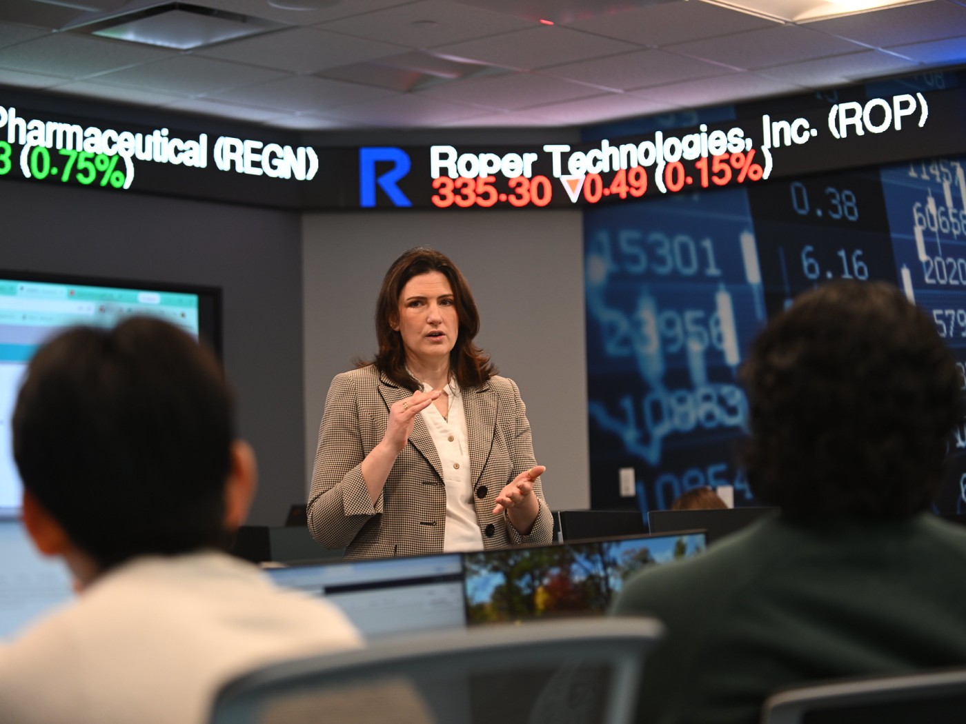 Female speaker with tickertape in background
