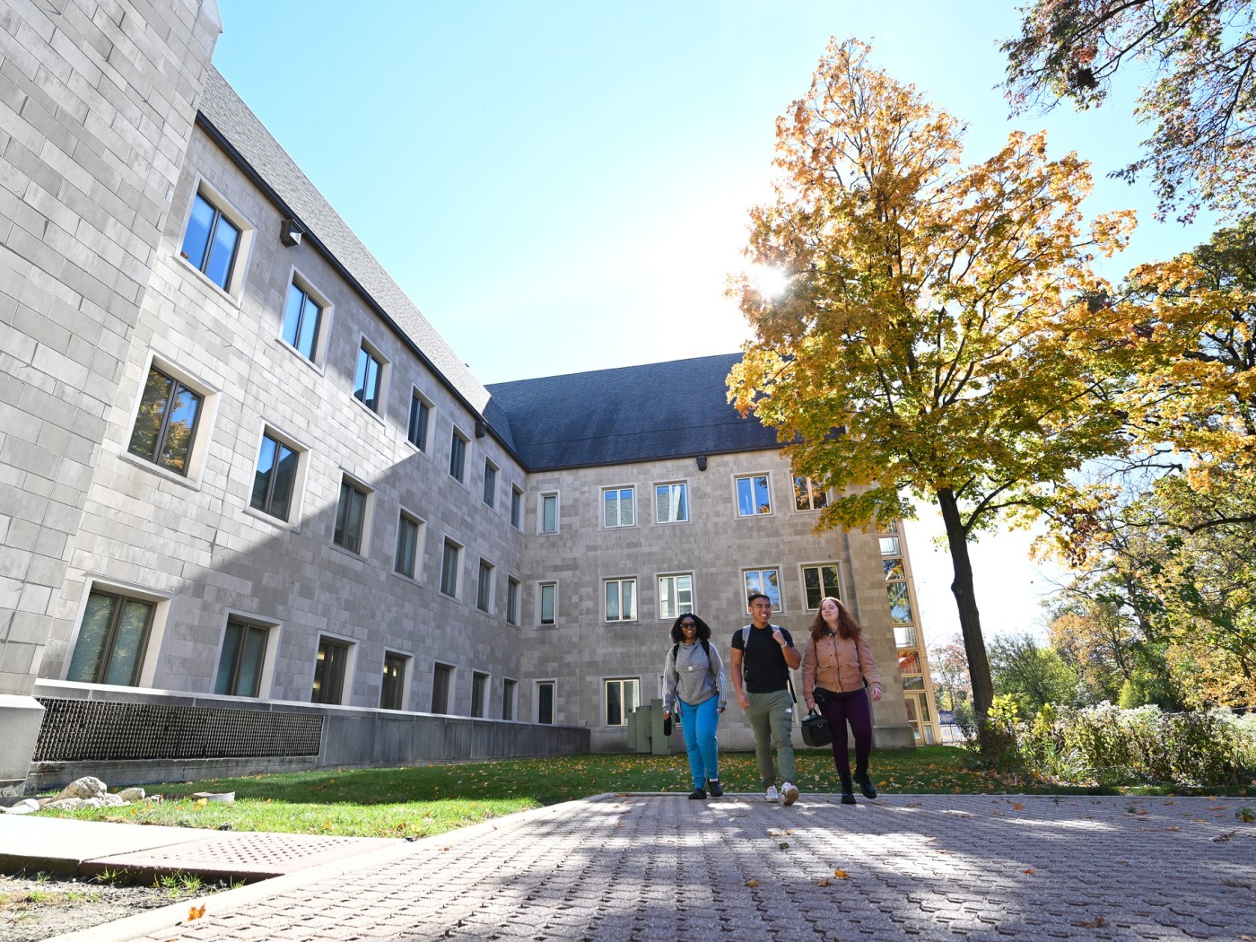 Three students walking near academic bu8ilding
