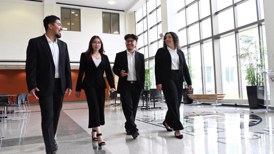 Four professionally dressed students walking